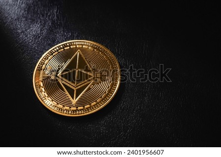 Golden Ethereum is an asset of choice for many investors, close up Golden Ethereum ETH coin , Ethereum ocin crypto currency on black leather and bright light background.