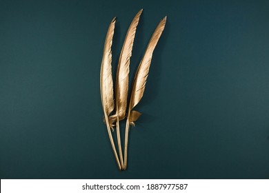 The Golden feather. Pattern with gold colored feathers on a trendy green emerald background. The view from the top. Flatly. - Shutterstock ID 1887977587