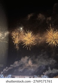 Golden fireworks exploding in the night sky, creating a spectacular display of light and smoke. This festive imagery captures the excitement of a New Year's Eve celebration, national holiday, or grand opening event. The bright sparks against the dark background symbolize joy, success, and a vibrant night atmosphere, perfect for event posters and celebratory backgrounds.

A group of golden firework bursts radiating from the center against a dark, hazy night sky. The shot captures the intricate light trails and the atmospheric smoke left by the explosions, creating a dynamic and textured visual experience. Ideal for abstract night photography themes, festive digital marketing materials, and high-energy background elements.

Stunning golden firework display lighting up the midnight sky during a summer festival or anniversary party. The warm tones of the sparks contrast beautifully with the dark sky, evoking a sense of wonder and grand celebration. This high-quality shot is suitable for editorial use in travel magazines or commercial use in holiday-themed advertising.
