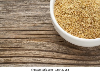 Golden Flaxseed Meal - A Ceramic Bowl On Grained Wood Background