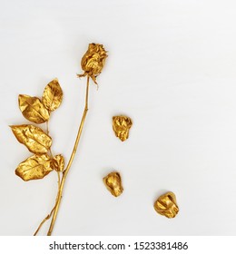 Golden flower rose close up with fall petals on light concrete background. Creative decoration plant painted gold metallic color. Bright fashion flower.  - Powered by Shutterstock