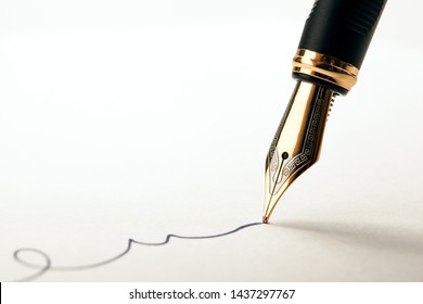 golden fountain pen leaves a signature on a white paper closeup - Shutterstock ID 1437297767