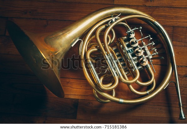 Golden french horn\
with Wooden Background