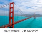 Golden Gate Bridge in San Francisco California. San Francisco skyline view through the suspension cables of Golden Gate Bridge on a foggy day. Downtown view bay cloud car. Red Golden Gate