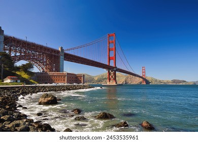 Golden Gate Bridge in San Francisco on a Sunny Blue Sky Day with Fort Point National Historic Site Along the Promenade, California. Tourist Destination and Famous Landmark in the United States. - Powered by Shutterstock