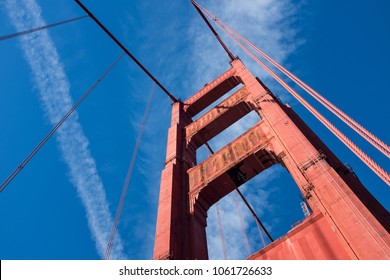 Golden Gate Bridge Suspension Cables, From The Ground Looking Up, Red Rusty Metal With Clear Blue Bright Clear Sky With Few Airplane Trails, Perspective Angle