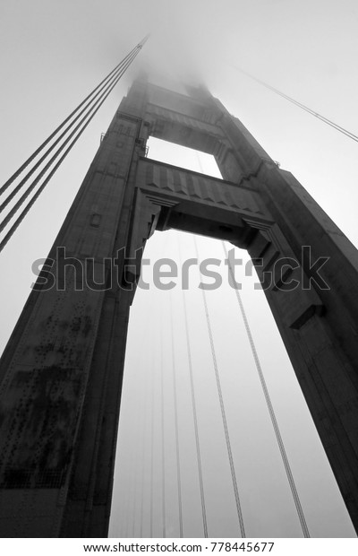 Golden Gate Bridge tower in black and\
white with fog rolling, San Francisco,\
USA