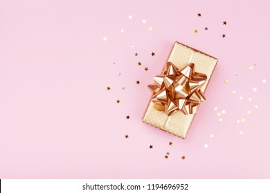 Golden gift or present box and stars confetti on pink table top view. Flat lay composition for birthday, christmas or wedding. - Powered by Shutterstock