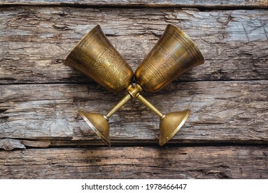 Golden goblets on the old wooden table background. Royal drink concept. - Shutterstock ID 1978466447