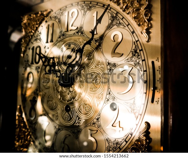Golden grandfather clock close up after 10:00 pm\
time at night with regal\
chimes
