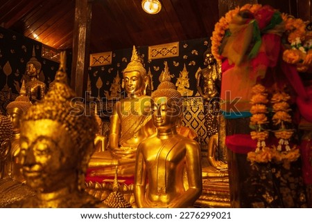 Golden group buddha faces statue meditation sitting with a Golden Buddha background up down and sitdown. Buddha in meditation posture during seated.