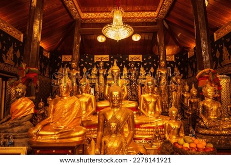 Golden group buddha faces statue meditation sitting with a Golden Buddha background up down and sitdown. Buddha in meditation posture during seated.