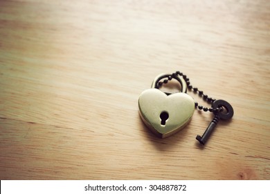 Golden heart love lock and key on wooden background. Abstract of love. Vintage effect. - Powered by Shutterstock