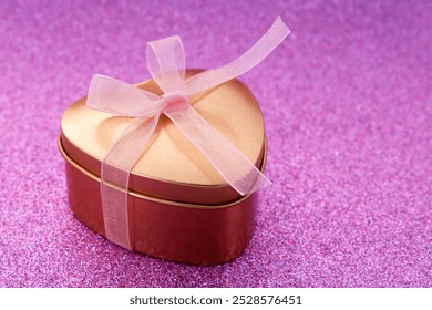 Golden heart shaped gift box with pink bow - Powered by Shutterstock