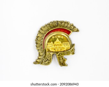 Golden Helmet Of Roman Legionary With Inspiration Roma On White Fridge Background. Classic Souvenir Magnet From Rome, Italy. Top View Flat Lay, Close Up.