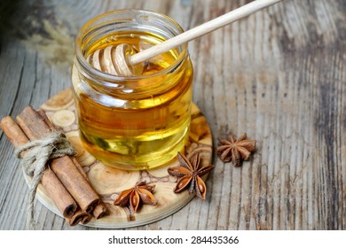 Golden honey with honeystick. cinnamon and anise stars on wooden table - Powered by Shutterstock