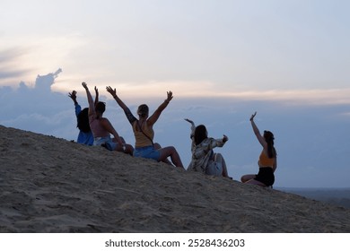 Golden Hour Bliss: Women Celebrating at Rainbow Beach Dunes, Australia with Hands Raised to the Sky Amidst Beautiful Clouds - Powered by Shutterstock