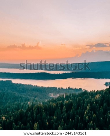 Golden Hour Glow: Tranquil Waterscape with Silhouetted Trees, Vibrant Colors Display, and Atmospheric Mood Setting - Captivating Nature Photography”