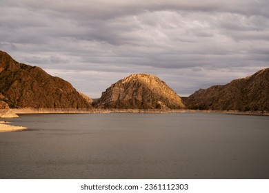 Golden hour in the mountains. View of the rocky cliffs and lake at sunset with a beautiful dramatic light.	 - Powered by Shutterstock