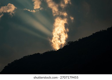 golden hour sunrays between clouds 