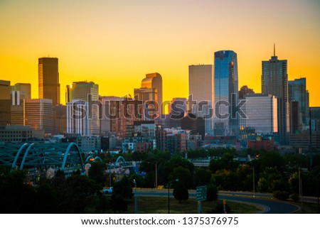 Golden hour sunrise silhouette Denver Colorado skyline cityscape the mile high city along the front range of the Rocky Mountains Rising skyscrapers and condo new development