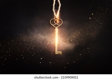 Golden key with glowing lights and dark background, wisdom, wealth, and spiritual concept - Shutterstock ID 2159909051