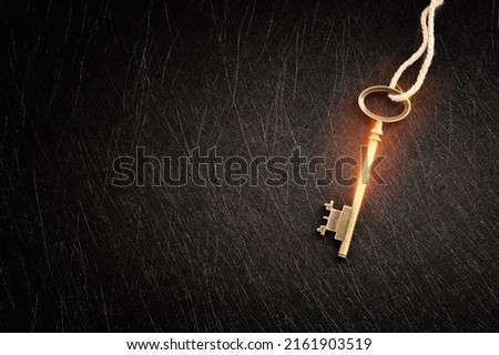 Golden key with glowing lights and dark background, wisdom, wealth, and spiritual concept