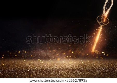 Golden key with glowing lights and dark background, wisdom, wealth, and spiritual concept