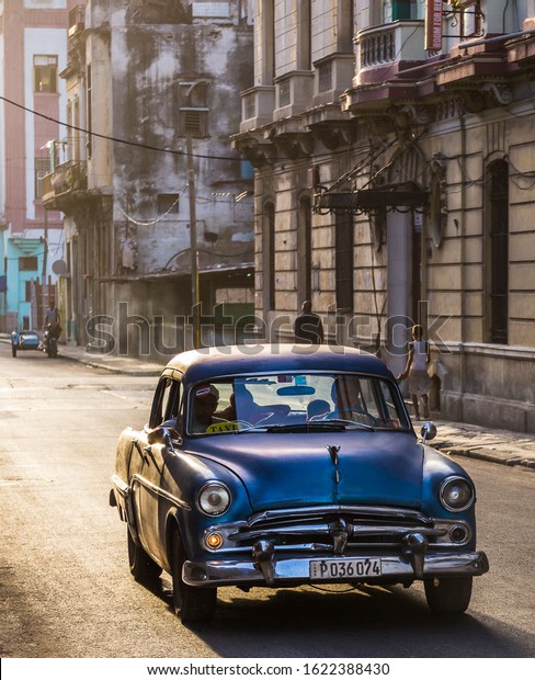 The golden light of another stunning\
Caribbean sunset bathes a purple classical car in soft light one\
evening in Centro Havana during August\
2014.
