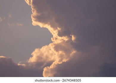 Golden light transforms a dramatic sky full of beautiful, fluffy clouds.
