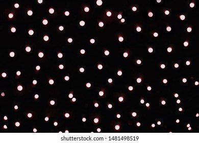 Golden lights with red tint blurred bokeh, dark background with many flashing circles. - Powered by Shutterstock