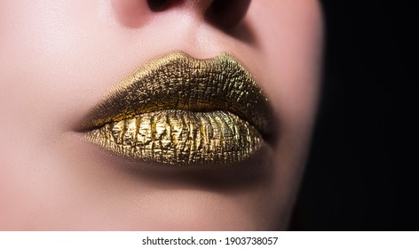 Golden lips. Woman sexy lip makeup isolated on black background