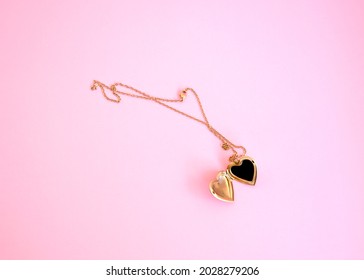 Golden Locket Necklace over a modern pink background
