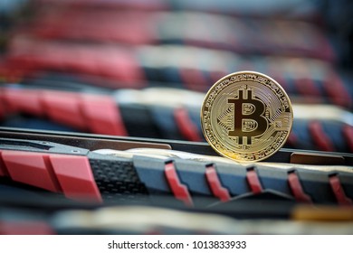 Golden metal coin as symbolic version of Bitcoin cryptocurrency on a background of mining electronic parts . Cryptocurrency mining and trading concept.  - Shutterstock ID 1013833933