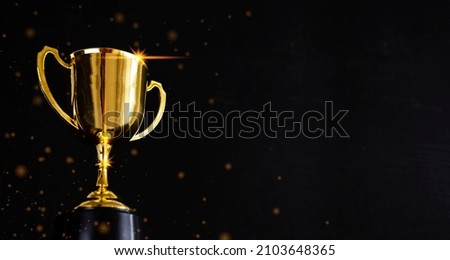 Golden metal glasses on old wooden table background, place for copy space. Golden wooden table with golden trophy on dark background. Ready for new year celebration design. Festive light background.