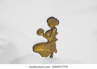 Golden metallic idol of  Indian hindu angel or apsara with flowers in hand isolated on a white background