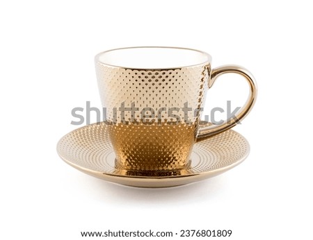 Golden metallic tea cup with saucer isolated on white background with clipping path