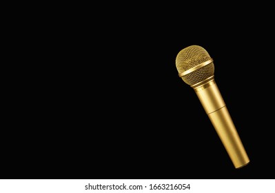 Golden microphone on black background.