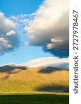 Golden mountain range under dramatic clouds, South Island, New Zealand