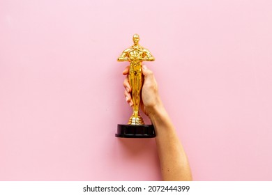 Golden Movie Award Statue In Hand. Cinema Industry Concept