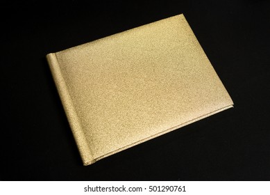 Golden notebook and pen isolated on Black background.