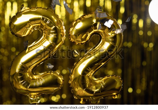 Golden number 22 twenty two\
made from an inflatable balloon, on a yellow background. One of the\
complete set of numbers. The concept of birthday, anniversary,\
date