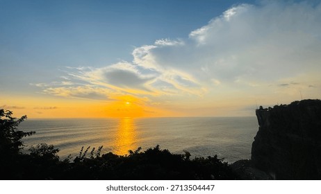 Golden Ocean Sunset With Dramatic Clouds and Cliff Silhouette