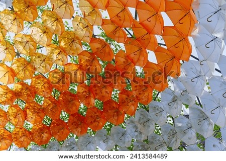 Golden, orange white umbrellas suspended in the air