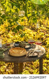 Golden Organic Healthy Crispy Pie Quiche With Artichokes, Dried Tomatoes And Olives, Glasses Of Wine On The Table, Evening Romantic Sunlight Dinner In The Summer Garden, Soft Selective Focus