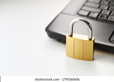 Golden Padlock On A Black Laptop Keyboard Over White Background. Internet Security Concept. Antivirus Software Concept. Electronic Wallet Symbol.