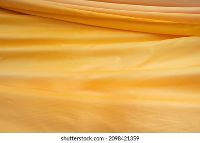 Golden Pagoda Robe Texture Pattern Background. Close-up On Yellow Wavy Backdrop.