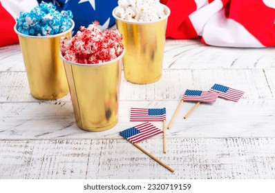 Golden paper cups with red, blue, white popcorn. US colors for 4th july. Snack food for USA independence day celebration - Powered by Shutterstock