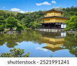 The Golden Pavilion (Kinkaku-ji) in Kyoto, Japan, reflects beautifully on the serene pond, surrounded by lush greenery and traditional Japanese gardens. 