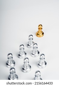 The golden pawn chess piece, leading in front of the group of silver pawn chess pieces, followers on white, vertical, stand out from the crowd. Leadership, Unique, influencer, difference concept. - Shutterstock ID 2156164433